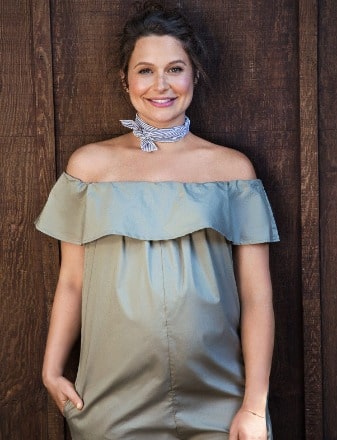 Katie Lowes posing for her photo shoot during her pregnancy by wearing crop dress.